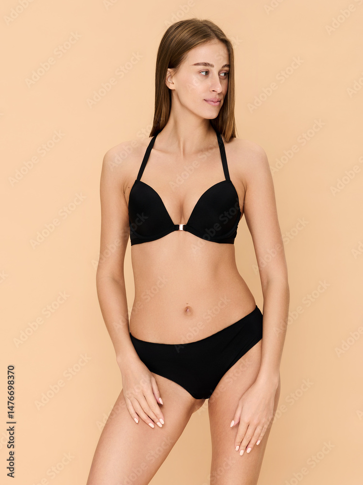 Girl model in lingerie posing on beige studio background. Girl model in lingerie posing on beige studio background.