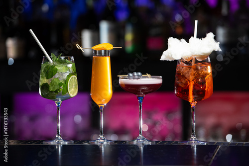 фотографія Five distinct and colorful cocktails are lined up on a sleek bar counter, each u