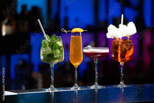 Bild auf Leinwand Five distinct and colorful cocktails are lined up on a sleek bar counter, each u