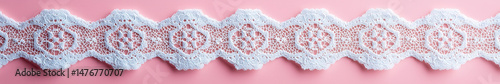 Delicate white lace pattern on pastel pink background