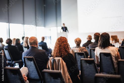 Speaker giving a talk in conference hall at business event. Rear view of unrecognizable people in audience at the conference hall. Business and entrepreneurship concept