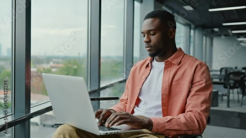 A handsome businessman is working on his laptop at his office desk