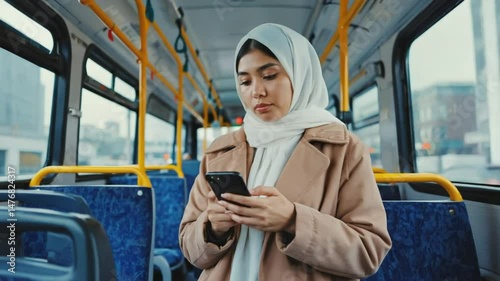 A young woman using the phone on the bus