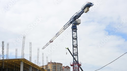 Cranes working on construction site in a city. Apartment buildings and crane at construction site. High quality 4k footage
