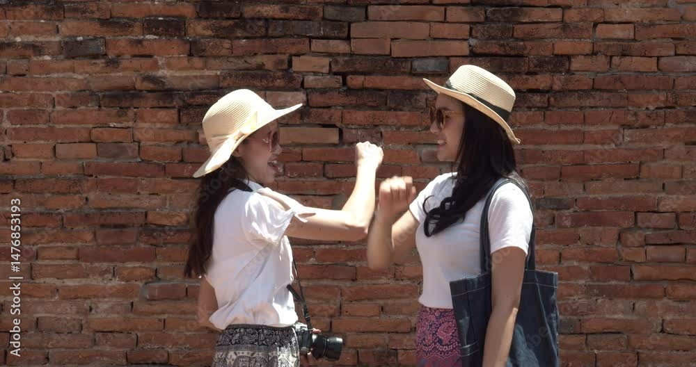 Two Asian female tourists visit Ancient Historical Park at Ayutthaya,Thailand.