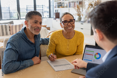 Happy Couple signing contact with financial advisor