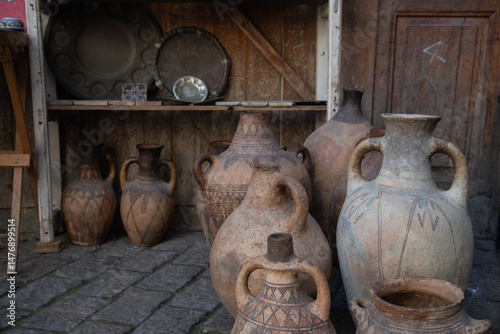 Ancient clay jugs and pots displayed in rustic setting of Fez photo