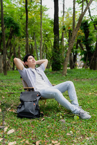 Relaxing young man enjoying nature in a lush green park during a sunny day