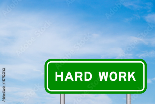 Green color transportation sign with word hard work on blue sky with white cloud background