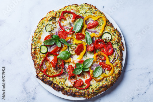 Vegan pizza on zucchini crust with vegetables and mozzarella.