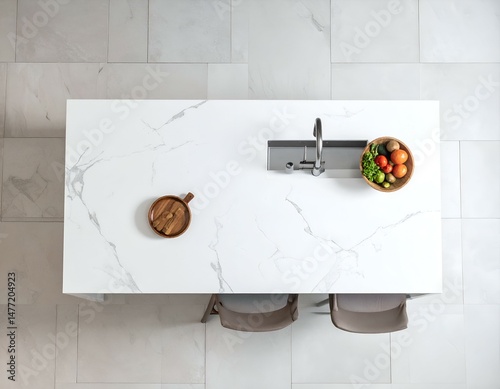 Overhead view of modern kitchen island with marble countertop, sink, wooden bowls of vegetables, and two chairs.