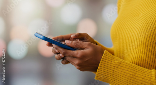 Woman's hands holding and interacting with a blue mobile phone