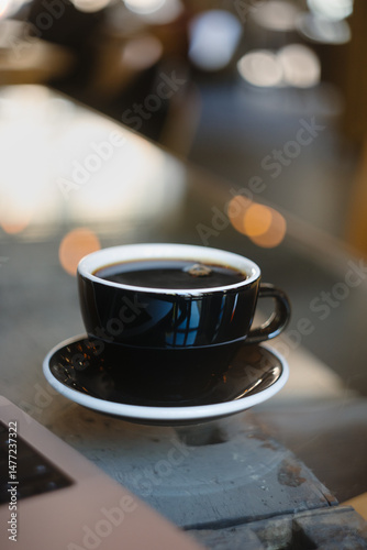 Delicious Black Coffee on a Table Surrounded by a Warm, Cozy Cafe Ambiance and Atmosphere