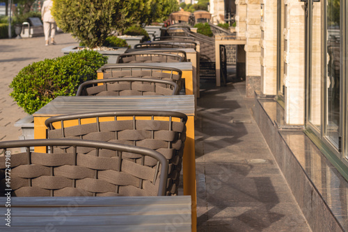 Tables at a street cafe on the city embankment before customers arrive