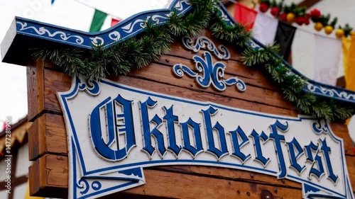 Colorful oktoberfest entrance sign with festive decorations and flags in motion
