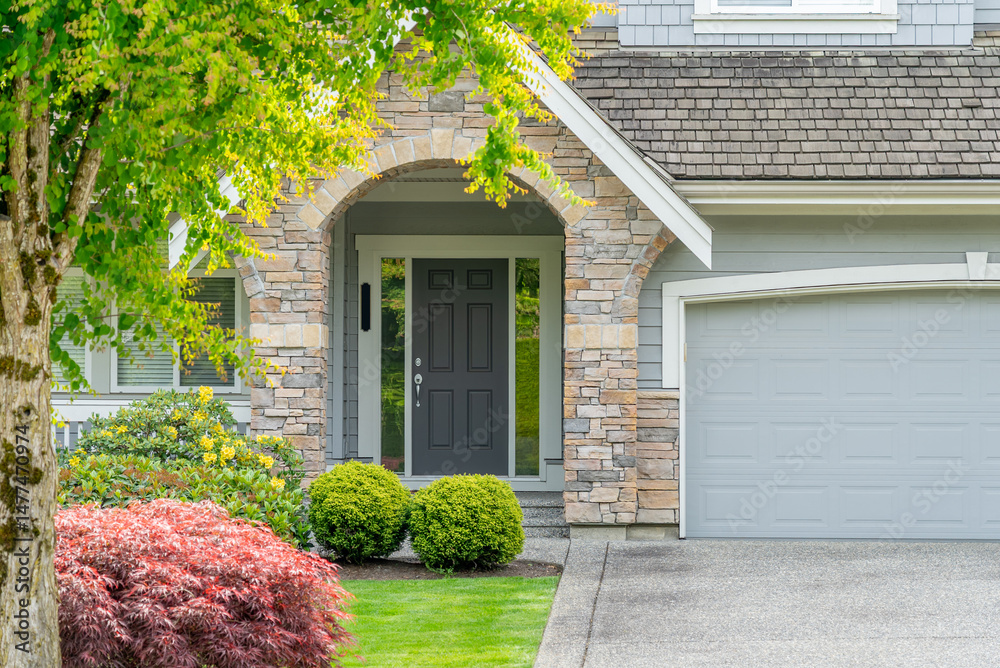 Fototapeta premium Entrance of grey painted luxury house in spring with stair steps and nice landscape in Vancouver, Canada, North America. Day time on April 2025.