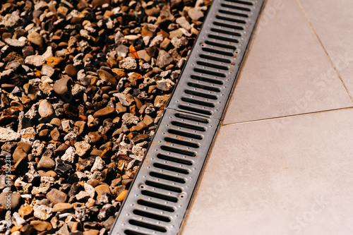 Fotografía An impeccably clean drainage grate situated next to beautifully arranged decorat