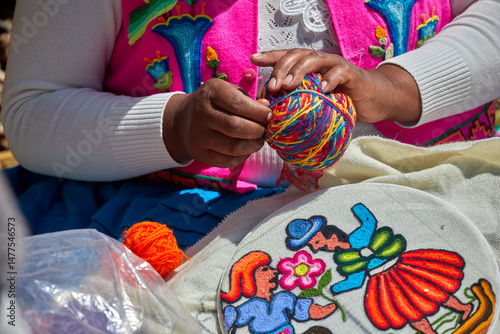 Wallpaper Mural skillful Uros hands at work, delicately embroidering traditional Andean patterns. Each stitch reflects generations of cultural knowledge and artistic expression. Puno Peru Torontodigital.ca