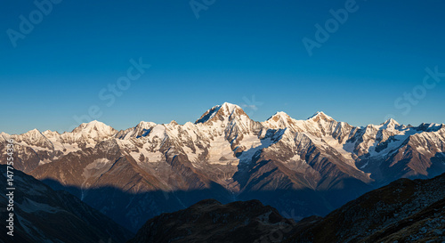 Majestic snow-capped mountains reaching towards the clear blue sky at daytime