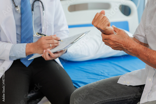 Obraz na płótnie Elderly man seeks medical advice for wrist pain after strenuous work, consulting a specialist to discuss symptoms and possible treatment. w salonie