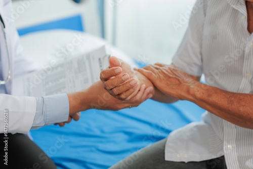 Obraz na płótnie Elderly man seeks medical advice for wrist pain after strenuous work, consulting a specialist to discuss symptoms and possible treatment. w salonie