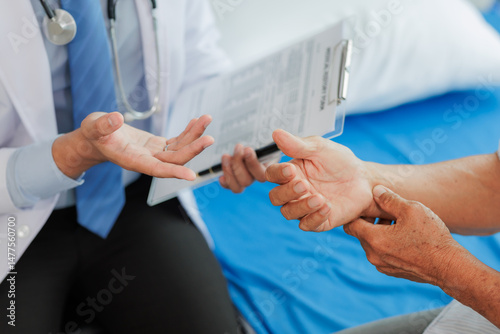 Obraz na płótnie Elderly man seeks medical advice for wrist pain after strenuous work, consulting a specialist to discuss symptoms and possible treatment. w salonie
