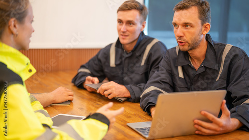 team of oil refinery engineers. wearing in safety wear, one man in casual wear, and another man in workwear  Business meeting, teamwork, and communication concept.