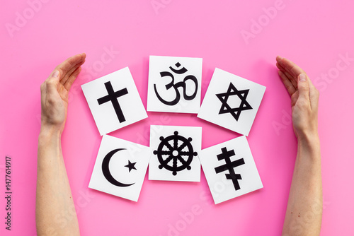 World religious concept. Hands holding Christianity cross, Islam crescent, Buddhism dharma wheel, Hinduism aum, Judaism David star symbols, top view