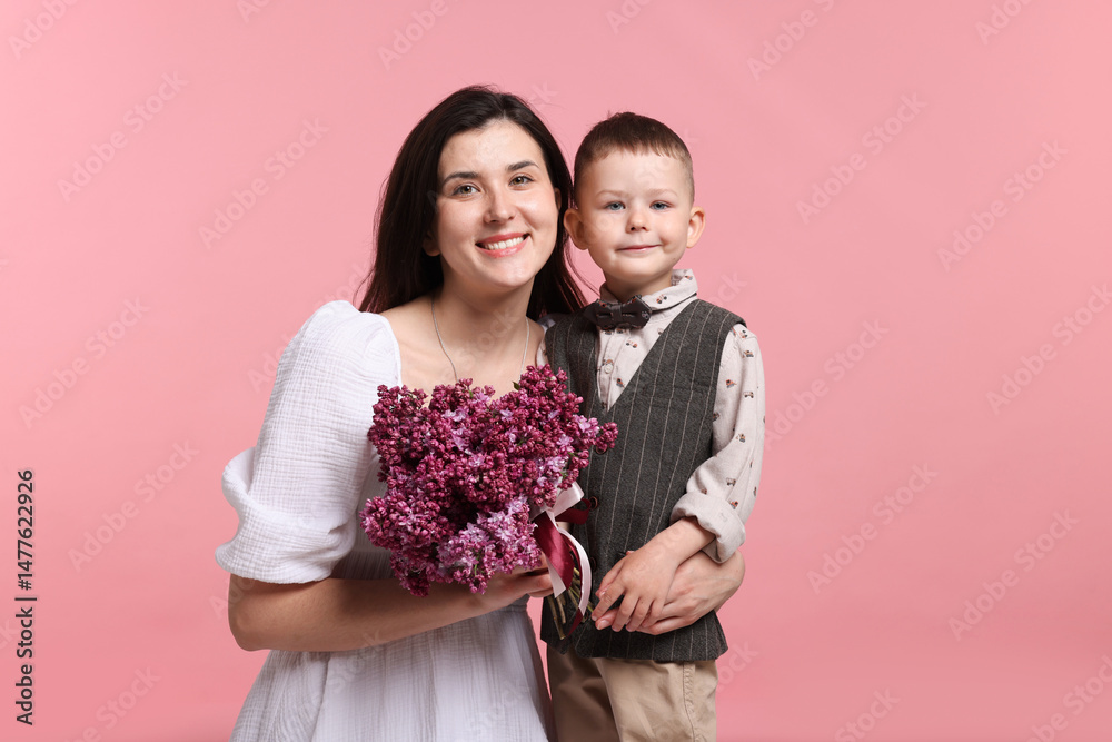 Mother and her son with bouquet of lilac flowers on pink background Mother and her son with bouquet of lilac flowers on pink background