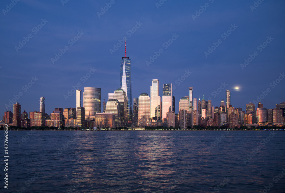 Obraz premium new york city skyline view during blue hour just after sunset (dusk nightfall night time photography from jersey city waterfront) hudson river downtown skyscrapers tall commercial buildings reflecting