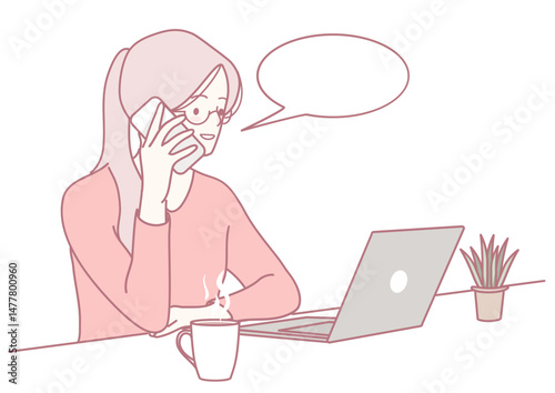 A modern woman, engaged in a business call, is using her laptop, with a convenient coffee cup nearby for ease