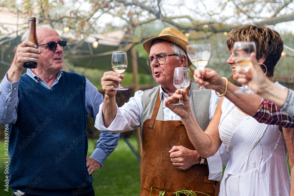 Fototapeta premium Senior friends toasting together during an outdoor celebration with wine and beer