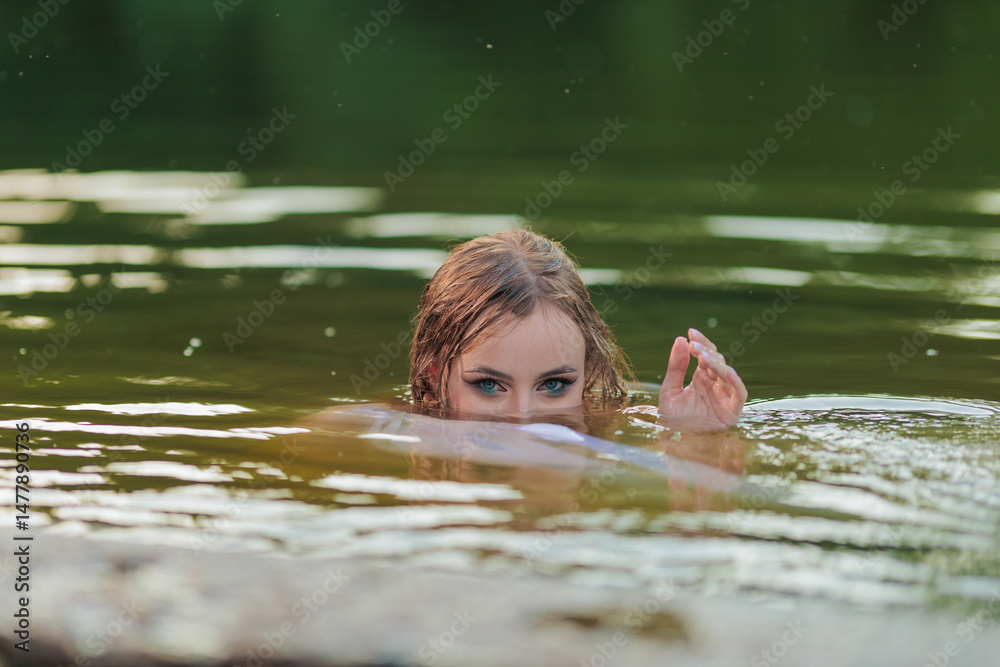 Fototapeta premium Beautiful Girl with long hair swims and dances in water