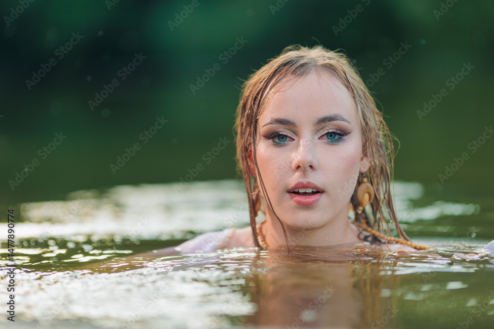 Obraz premium Beautiful Girl with long hair swims and dances in water