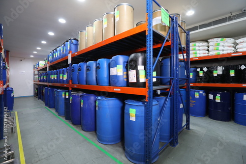 Pharmaceutical warehouse with blue storage containers on racks, clean epoxy flooring, cleanroom environment in supplement or medicine manufacturing facility.