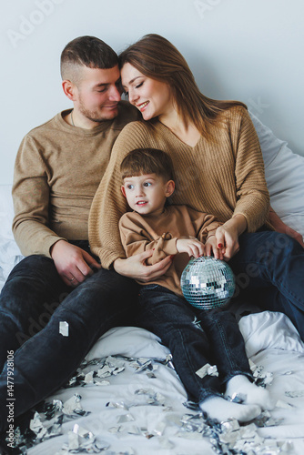Obraz na płótnie Cozy Family Moment A Joyful Family Embracing Togetherness with a Beautiful Shimmering Disco Ball Enhancing their Special Time Together, Creating Lasting Memories in Their Loving Home Environment w salonie