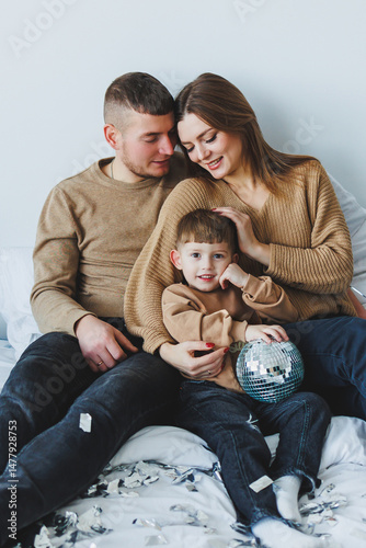 Obraz na płótnie Cozy Family Portrait A Heartwarming Moment Captured Indoors Featuring a Joyful Child Engaged with Their Loving Parents, Surrounded by Comfortable Decor and Warm Expressions of Affection and Happiness w salonie