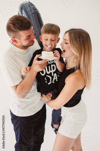 Obraz na płótnie Mom, dad and son celebrate their son's birthday. 4 year old boy eats sweet birthday cake. w salonie