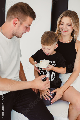 Obraz na płótnie Mom, dad and son celebrate their son's birthday. 4 year old boy eats sweet birthday cake. w salonie