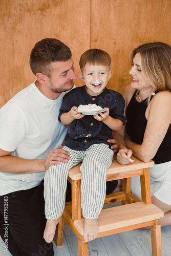 Obraz na płótnie A Joyful Family Portrait Parents and Their Child Celebrating Together in a Cozy Atmosphere, Capturing Precious Moments of Love and Togetherness in a Happy and Emotional Family Setting w salonie