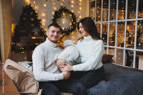 Obraz na płótnie Experience a heartwarming family moment by the fireplace, adorned with holiday lights as everyone wears cozy sweaters, creating an ambiance of joy and togetherness this festive season w salonie