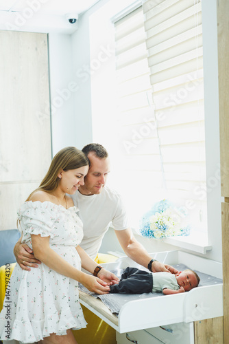 Obraz na płótnie Newly Became Parents Cherishing Beautiful, Precious Moments with Their Newborn in a Bright, Cheerful Nursery Setting that is Filled with an Abundance of Natural Light and Joyful Atmosphere w salonie