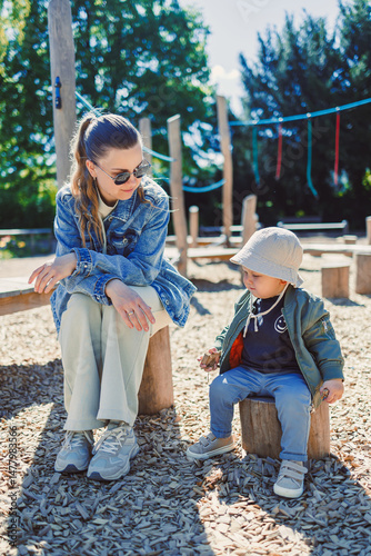 Obraz na płótnie A lovely scene where a mother and her child are seen joyfully spending a delightful day together at the playground, basking under the bright and warm sunshine, creating treasured memories w salonie