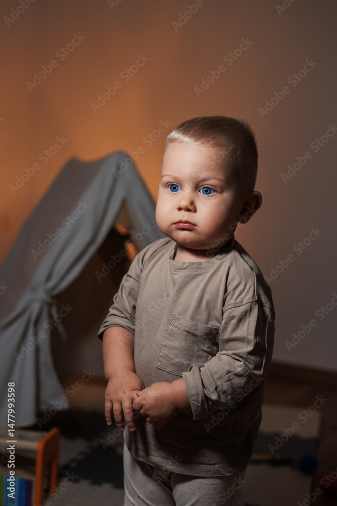 In a bright and colorful room filled with warm lighting, a cheerful young child stands happily, embodying a cozy atmosphere that is perfect for exploration and creating joyful moments of childhood