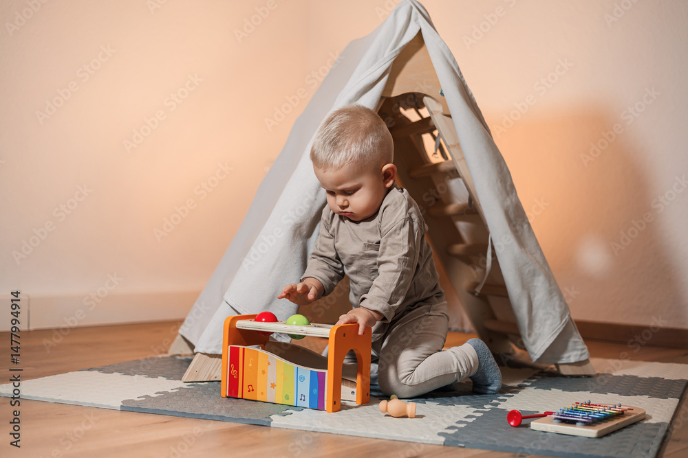 An absolutely adorable baby is joyfully playing with a colorful musical toy while nestled inside a cozy indoor tent, creating a warm and inviting atmosphere for exploration and fun