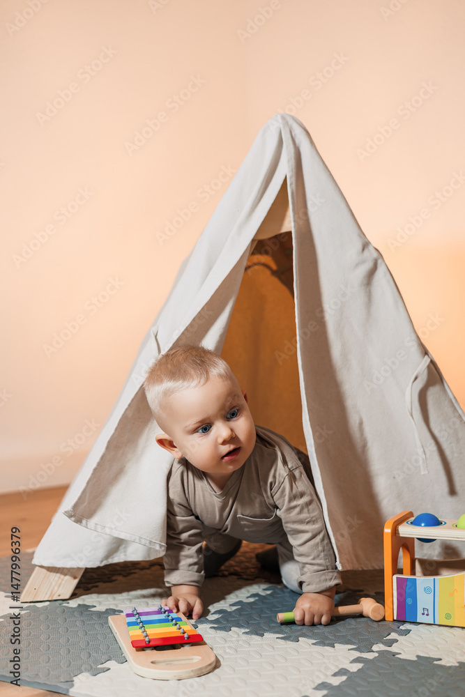 A joyful and playful toddler is having a great time exploring a cozy tent filled with a variety of colorful toys in a modern playroom designed for fun and creativity, perfect for child development