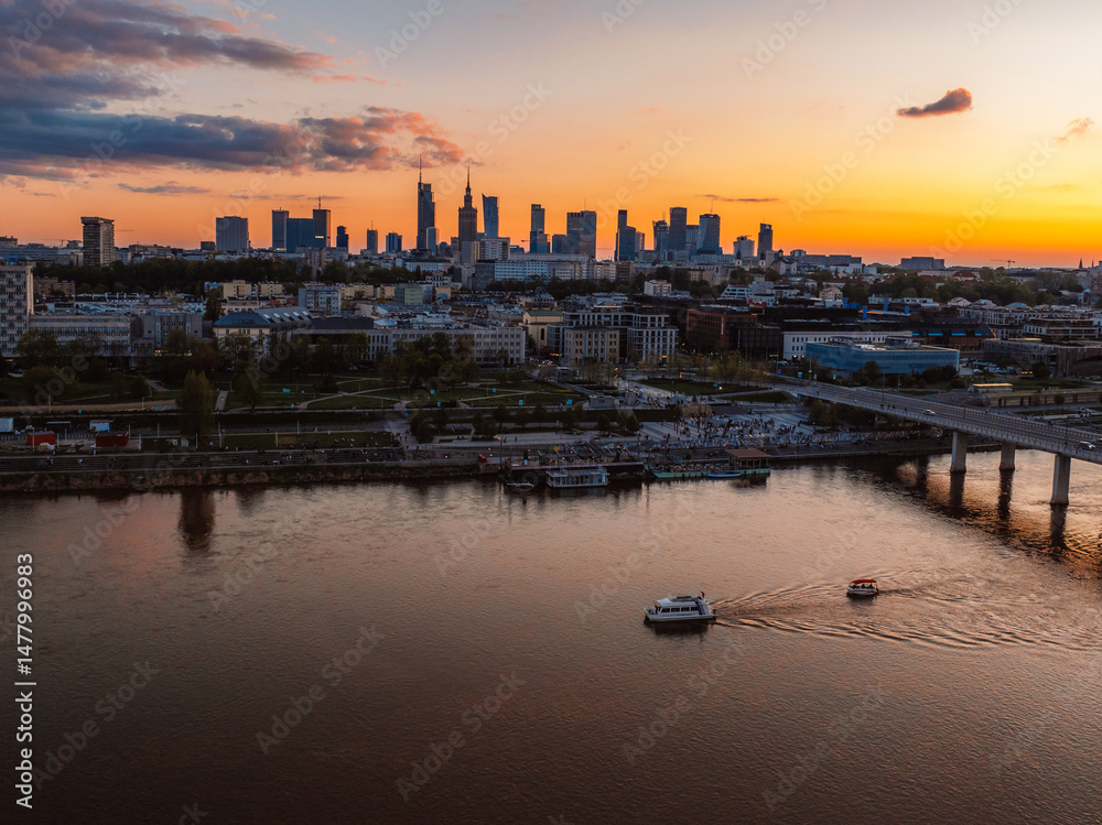 Naklejka premium Warsaw city center and skyscrapers in the background Vistula river and Swietokrzyski bridge. Sunset Warsaw aerial view.