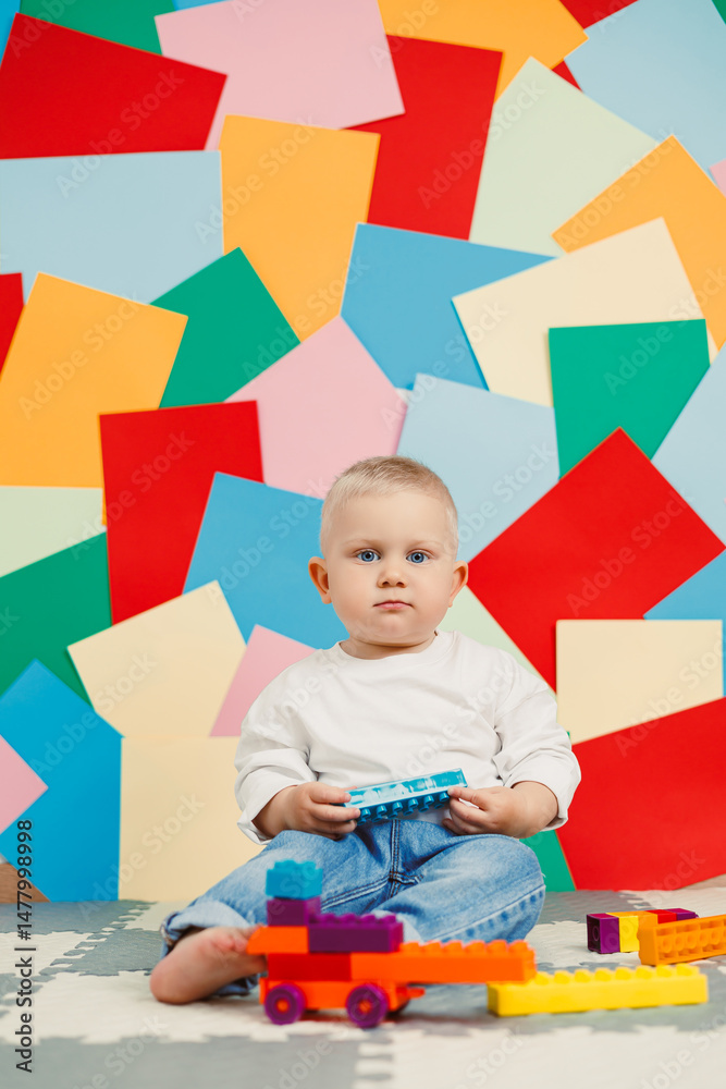 An adorable toddler is fully engaged, immersed in playing with colorful building blocks, surrounded by a vibrant artstyle background that enhances the joyful atmosphere of creative exploration