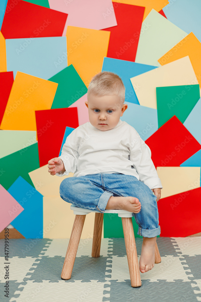 In a cozy indoor setting, a happy child sits on a modern stool, surrounded by colorful paper cutouts that enhance the atmosphere with vibrant artistic flair, capturing the essence of childhood joy