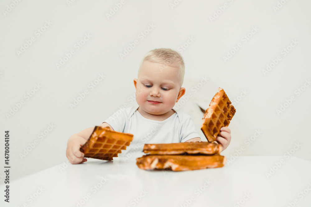 A little child seated at the table, enjoying delicious wafflesthis captures a sweet and joyful moment in their life. Its a celebration of childhood filled with innocence and happiness